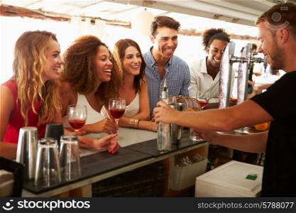 Group Of Friends Enjoying Drink At Outdoor Bar