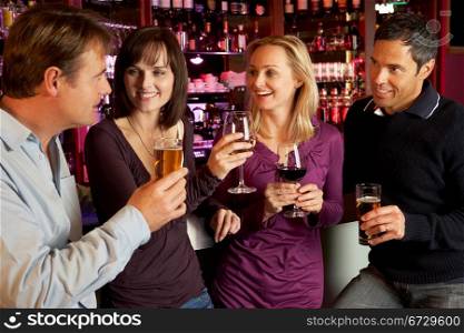 Group Of Friends Enjoying Drink Together In Bar