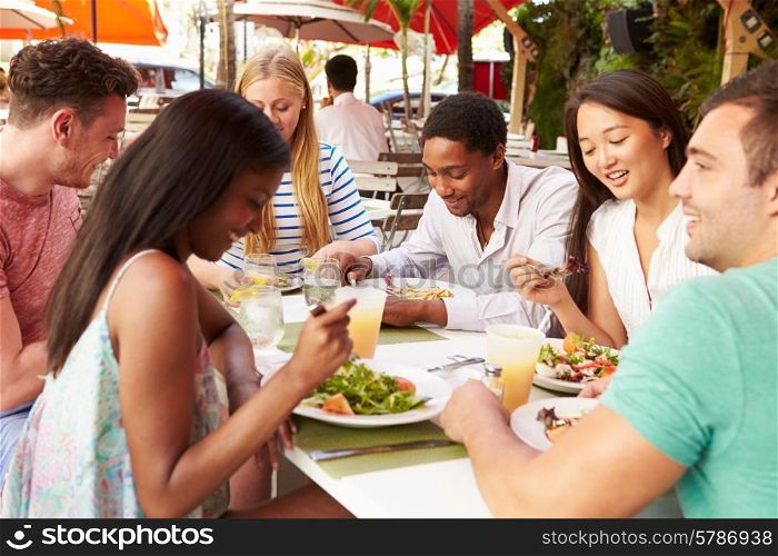 Group Of Friends Enjoying Lunch In Outdoor Restaurant
