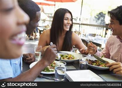 Group Of Friends Enjoying Meal At Outdoor Restaurant