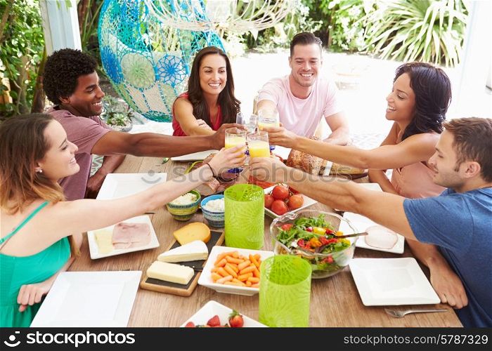 Group Of Friends Enjoying Meal Outdoors At Home