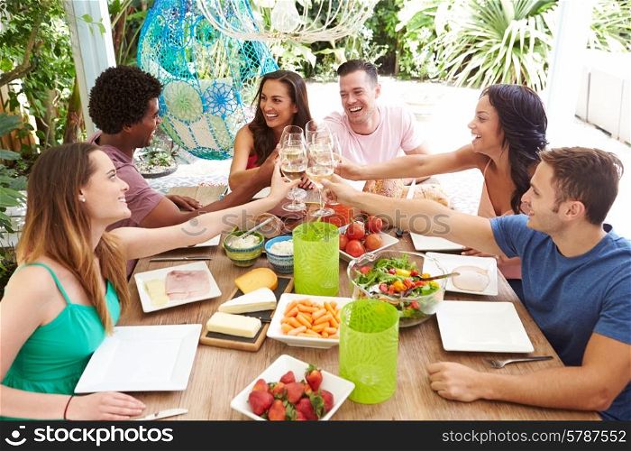 Group Of Friends Enjoying Meal Outdoors At Home