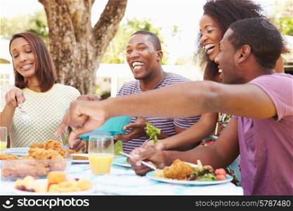 Group Of Friends Enjoying Outdoor Meal At Home