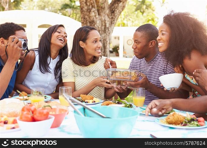 Group Of Friends Enjoying Outdoor Meal At Home