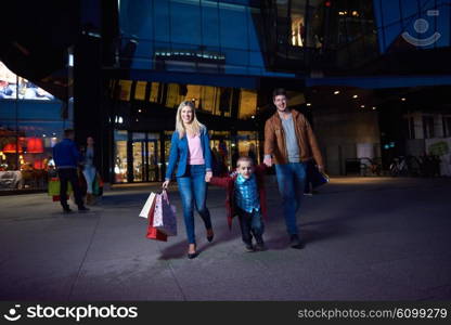 Group Of Friends Enjoying Shopping Trip Together&#xA;group of happy young frineds enjoying shopping night and walking on steet on night in with mall in background