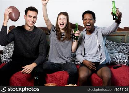 Group of friends having fun at home, watching game and Celebrating Goal.