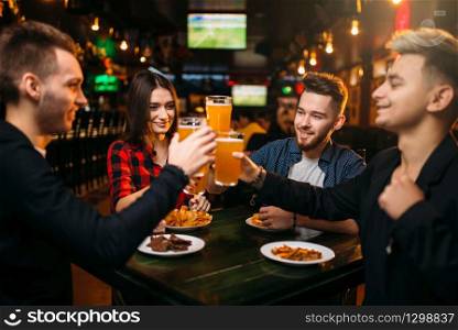 Group of friends having fun in a sport bar and drinks beer, happy football fans. Group of friends having fun in a sport bar