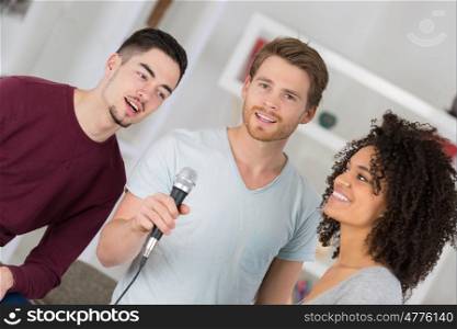 group of friends having fun karaoke singing at home