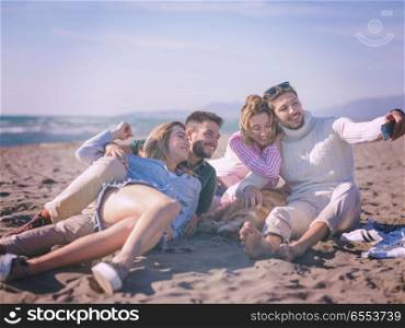 Group of friends having fun on beach during autumn day. Group Of Young Friends Spending The Day On A Beach during autumn day colored filter
