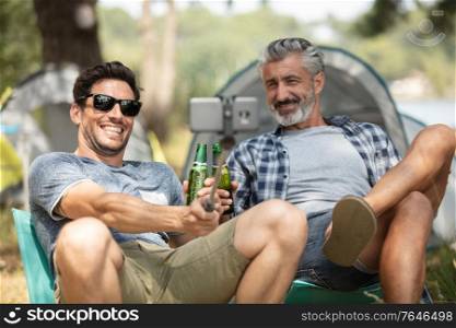group of friends in countryside on camping trip taking selfie