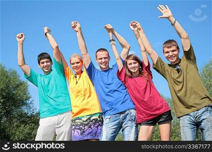 Group of friends in multicolor shirts with rised hands