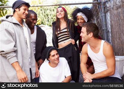 Group Of Friends In Urban Setting Standing By Fence