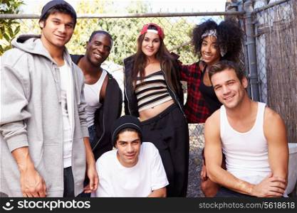 Group Of Friends In Urban Setting Standing By Fence
