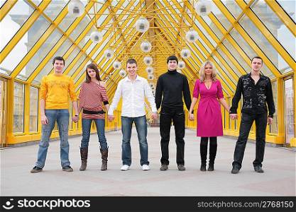 group of friends it stand taking hands on footbridge