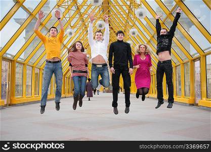group of friends jump on footbridge