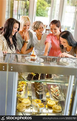 Group of friends looking at cakes cafe women happy choosing