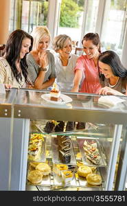 Group of friends looking at cakes cafe women happy choosing