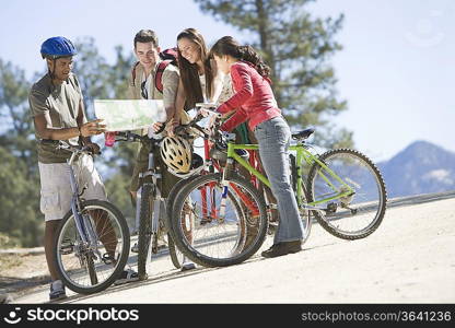 Group of friends looking at map on cycling holiday