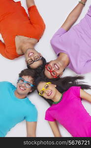 Group of friends lying with their heads together on white background