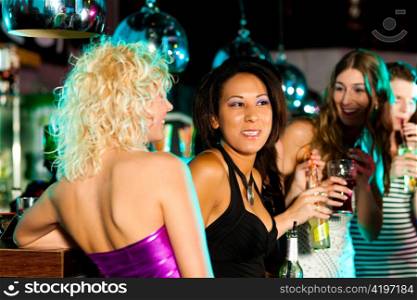 Group of friends - men and women of different ethnicity - having fun in a disco or nightclub