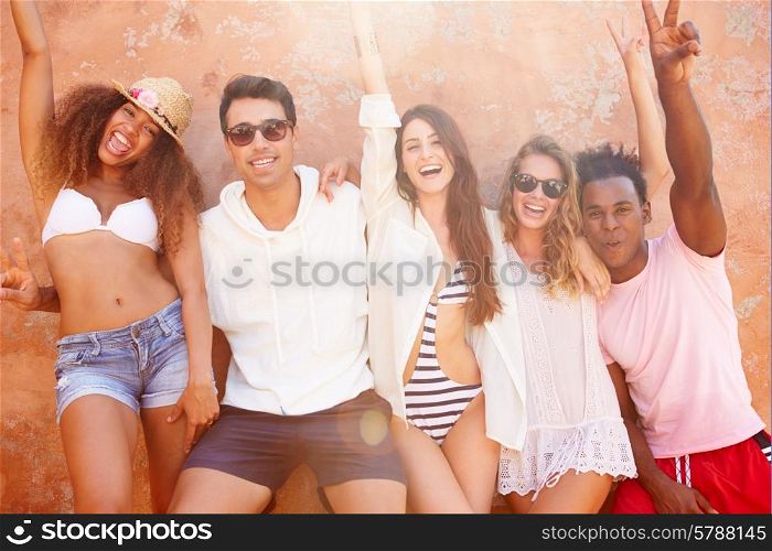 Group Of Friends On Holiday Together Posing By Wall