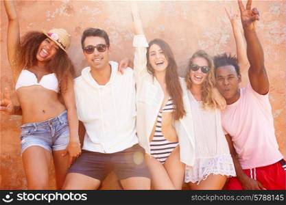 Group Of Friends On Holiday Together Posing By Wall