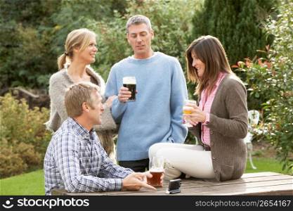 Group Of Friends Outdoors Enjoying Drink In Pub Garden