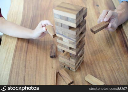 Group of Friends playing blocks wood game on the table folded puzzle