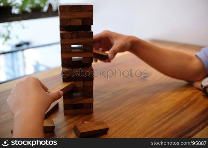 Group of Friends playing blocks wood game on the table folded puzzle