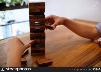 Group of Friends playing blocks wood game on the table folded puzzle