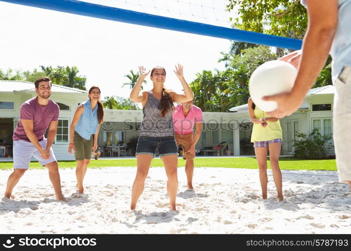 Group Of Friends Playing Volleyball In Garden