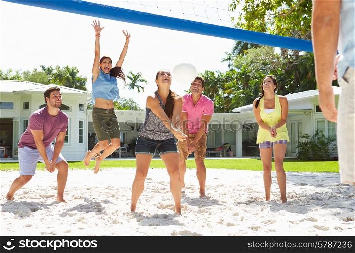 Group Of Friends Playing Volleyball In Garden