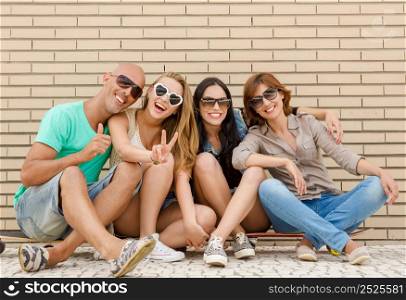 Group of friends posing in front of a brick wall