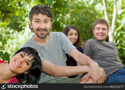 group of friends relaxing outdoors, focus on the man on the left