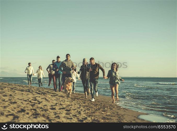 Group of friends running on beach during autumn day. group of young friends spending day together running on the beach during autumn day colored filter
