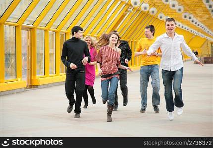 group of friends runs on footbridge