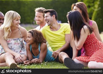 Group Of Friends Sitting On Grass Together
