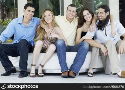 Group of friends sitting together on a couch and smiling