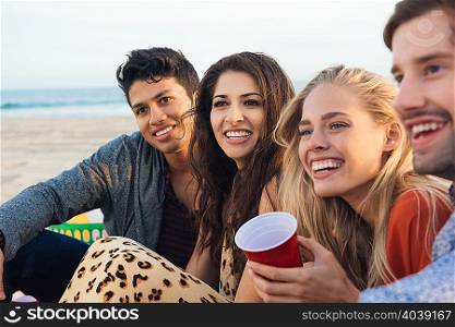 Group of friends sitting together on beach