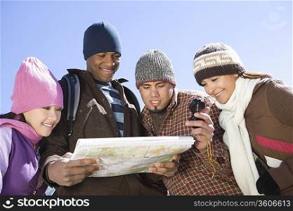 Group of friends stand looking at map together