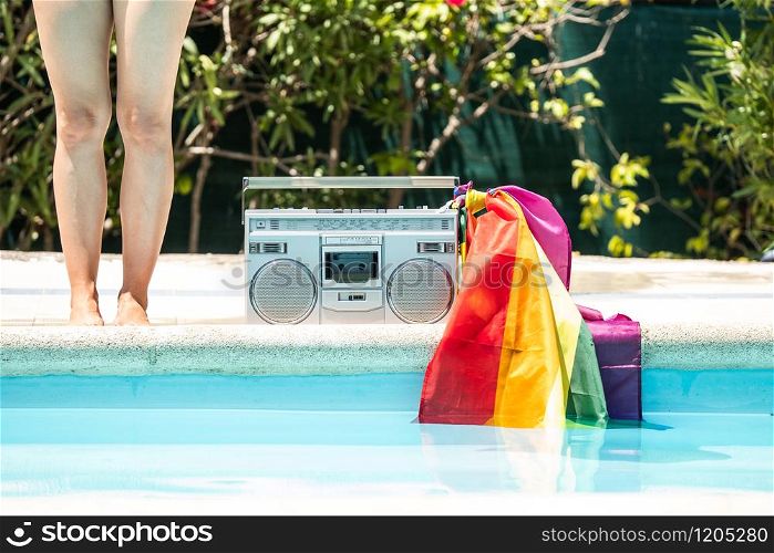 Group of friends sunbathing in the pool with old record player. lgtbi movement
