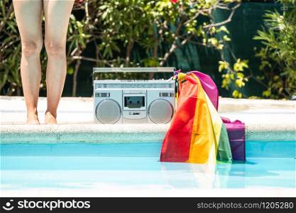 Group of friends sunbathing in the pool with old record player. lgtbi movement
