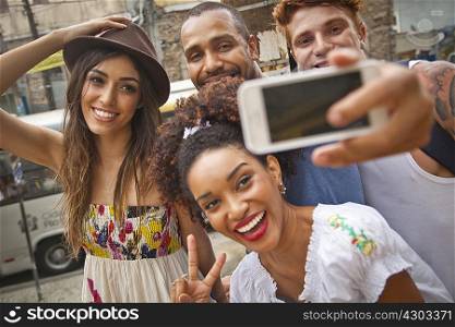 Group of friends taking self portrait, using smartphone