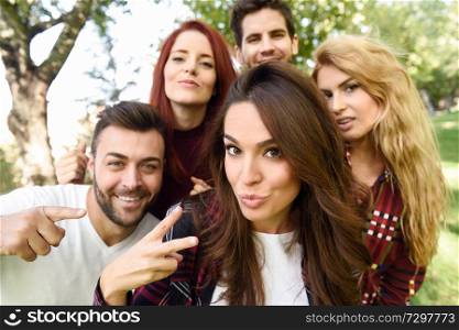 Group of friends taking selfie in urban background. Five young people wearing casual clothes.. Group of friends taking selfie in urban background