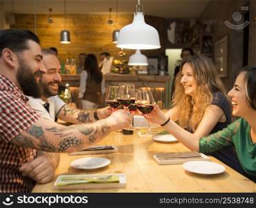 Group of friends toasting and having a good time at the restaurant