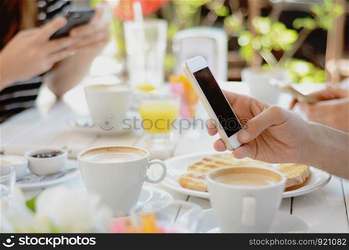Group of friends using smartphone at coffee shop. Communication concept.