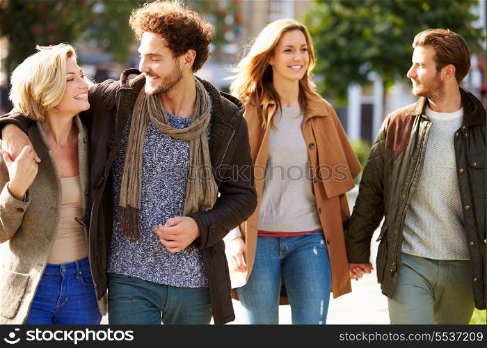 Group Of Friends Walking Through City Park Together