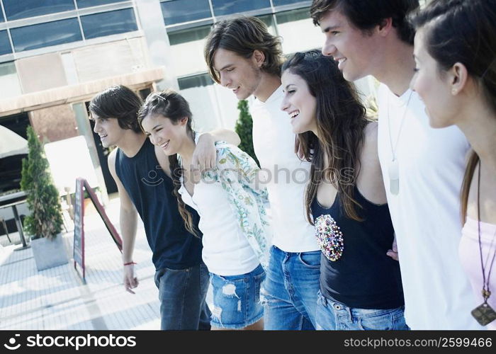 Group of friends walking together with their arms around each other