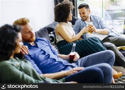 Group of friends watching TV, drinking cider  and having fun in the room