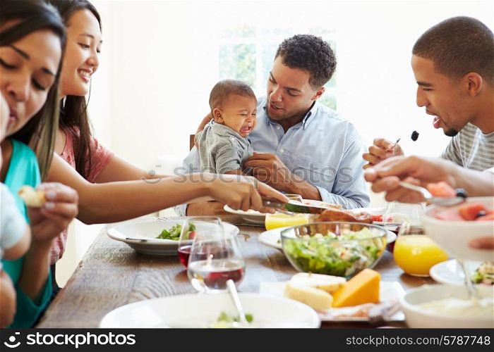 Group Of Friends With Babies Enjoying Meal At Home Together